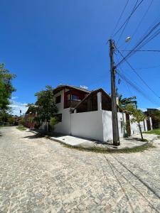 una strada con un edificio bianco e un palo del telefono di Kitnet aconchegante próximo à Praia do Forte a Mata de Sao Joao
