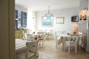 a dining room with white tables and white chairs at B&B Il Grifone in Gioia del Colle