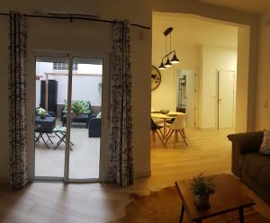 Apartamento Pepi Adults Only في سانتا بولا: غرفة معيشة مع باب زجاجي منزلق يؤدي إلى غرفة طعام
