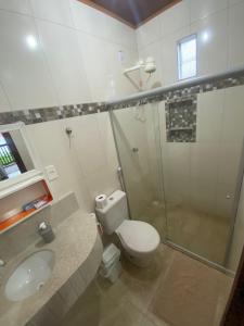 a bathroom with a toilet and a sink and a shower at Kitnet próximo à Praia do Forte in Mata de Sao Joao