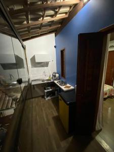 a kitchen with a stove and a sink in a room at Kitnet próximo à Praia do Forte in Mata de Sao Joao