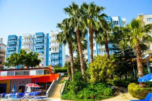 un hotel con palmeras frente a un edificio en Ark Apart and Suite Hotel, en Alanya