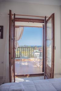 een slaapkamer met een deur naar een balkon bij BS Village in Metamorfosi