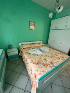 ein Schlafzimmer mit einem Bett mit einer grünen Wand in der Unterkunft •Oscar Sea Home• in Seccagrande