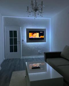 a living room with a couch and a tv on the wall at Apartman Bajo 1 in Foča