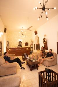3 persone sedute sui divani in soggiorno di New Old Dutch House - Galle Fort a Galle