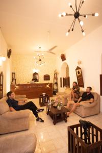 3 Personen sitzen auf Sofas im Wohnzimmer in der Unterkunft New Old Dutch House - Galle Fort in Galle