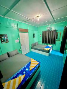 1 dormitorio con 2 camas en una habitación con paredes verdes en Khafii Village, en Kampong Pasir Panjang
