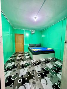 Kampong Pasir PanjangにあるKhafii Villageの緑の壁、ベッド付きのベッドルーム1室