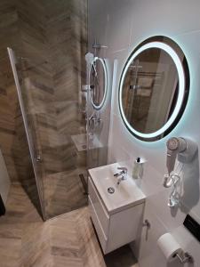 W łazience znajduje się prysznic, umywalka i lustro. w obiekcie Nowe M4 Żyrardów Centrum - blisko Suntago w mieście Żyrardów