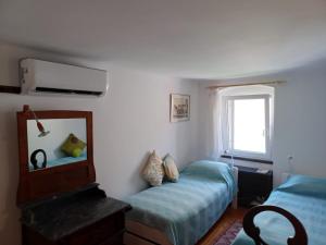 a bedroom with a bed and a mirror and a window at House Markovina in Cres