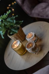 a table with three candles on a white plate at Le Spalace in Spa