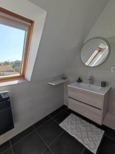 uma casa de banho branca com um lavatório e um espelho em GITE W 