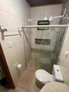 a bathroom with a toilet and a shower at Agradável Kitnet próximo à Praia do Forte in Mata de Sao Joao