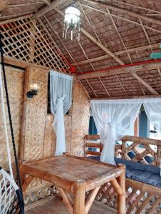 una camera con un tavolo in legno in una capanna di La Maison Guesthouse a Manlocahoc