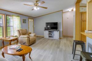 sala de estar con sofá, mesa y TV en Upstate NY Vacation Rental 1 Mi to Fairhaven Beach, en Red Creek