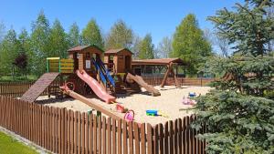 a childrens playground with a play equipment in the sand at Domki Romka in Mikołajki