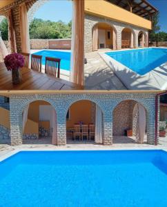 a villa with a swimming pool and a house at Holiday house with heated pool Vugica in Polje