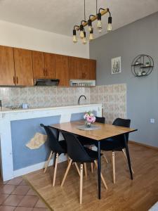 cocina con mesa de madera y sillas negras en Apartman Roza 2 en Ploče