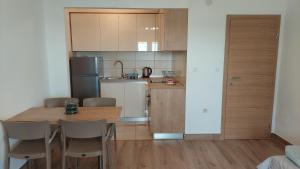 a kitchen with a wooden table and chairs in a room at Apartments Nikola Caska in Novalja