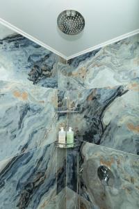 a bathroom with a shower with marble tiles at Arodamos Studios Apartments in Kissamos