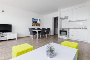 kuchnia i salon ze stołem i krzesłami w obiekcie Przestronny apartament Centrum między 2 jeziorami w Olsztynie
