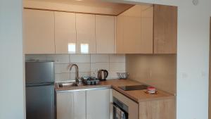 a kitchen with white cabinets and a stainless steel refrigerator at Apartments Nikola Caska in Novalja