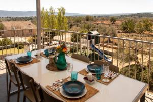 Chella的住宿－Casa Rural la Montana 1，阳台上配有带盘子和玻璃杯的白色桌子