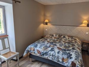 a bedroom with a bed and a chair and a window at Ferme Robin in Marsaz