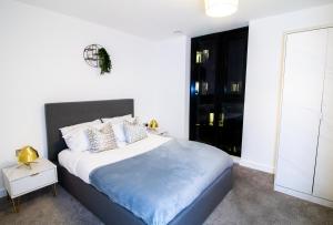 a bedroom with a large bed with white sheets and pillows at Beautiful place - 2 Bedroom Apartment on Broad Street in Birmingham