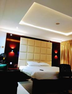um quarto com uma cama grande e luzes vermelhas em Brickland Residence em Abuja