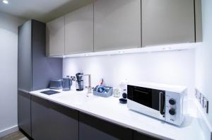 a kitchen with a white counter top with a microwave at Beautiful place - 2 Bedroom Apartment on Broad Street in Birmingham