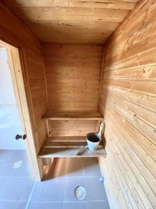 una pequeña sauna de madera con un tazón. en Männiliiva puhkemaja, en Hiiumaa