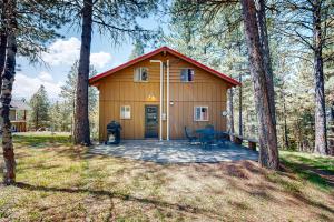 a small cabin with a porch in the woods at Pine Cone Cabin in Cascade