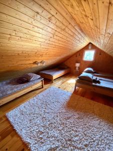 a wooden room with two beds and a rug at Männiliiva puhkemaja in Hiiumaa