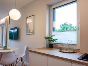 a kitchen with a table and a large window at VacationClub – Sosnowa 4 Apartament 25 in Mielno