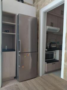 a kitchen with a stainless steel refrigerator in a room at Seaside pearl in Lygia