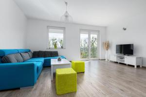 een woonkamer met een blauwe bank en een tv bij Przestronny apartament Centrum między 2 jeziorami in Olsztyn