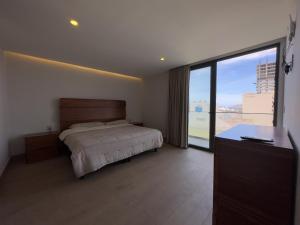 a bedroom with a bed and a large window at frente al malecón, 5 min zona dorada by G P S rentas in Mazatlán +30 photos