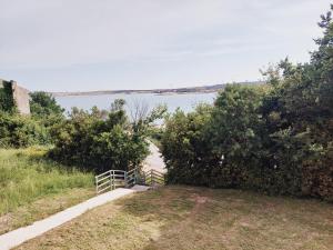 a path next to a body of water with a fence at Apartments Nikola Caska in Novalja