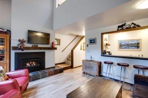 ein Wohnzimmer mit einem Kamin und 2 Barhockern in der Unterkunft 06SW - Fireplace - WithD - Kitchen - Sleeps 7 home in Glacier