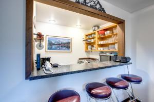 eine Bar mit Hockern vor einer Theke in der Unterkunft 06SW - Fireplace - WithD - Kitchen - Sleeps 7 home in Glacier