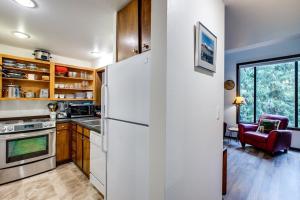 eine Küche mit einem weißen Kühlschrank und einem Tisch in der Unterkunft 06SW - Fireplace - WithD - Kitchen - Sleeps 7 home in Glacier