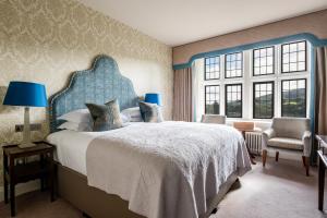 a bedroom with a large bed with a blue headboard at Bovey Castle in Moretonhampstead