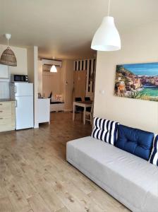 ein Wohnzimmer mit einem Sofa und einer Küche in der Unterkunft Apartament na Mierzei Wiślanej nad morzem in Jantar