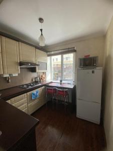 a kitchen with a white refrigerator and a table at Apartment in Shoduar's park in Zhytomyr
