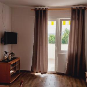 a living room with a door and a window at Apartments Nikola Caska in Novalja