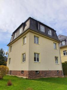 a large brick house with a black roof at Ferienwohnung Reichenbrand mit Stellplatz in Chemnitz