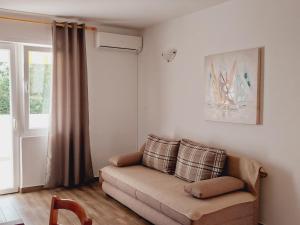 a living room with a couch and a window at Apartments Nikola Caska in Novalja