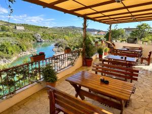 a patio with benches and a view of a river at Hotel Kalaja in Shkodër